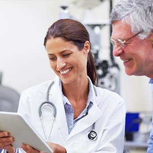 An older man and young female doctor review the results of an eye exam.