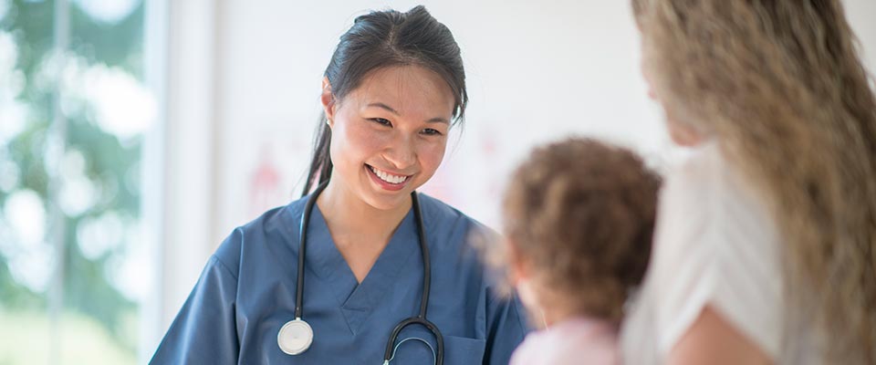 Healthcare provider demonstrates attentive bedside manner to mother and child.